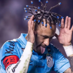 Neymar celebrates on the field with braided hair and blue beads while wearing a Santos FC jersey.